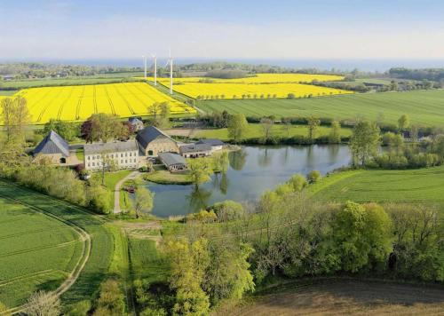 einen Luftblick auf einen Bauernhof mit einem Fluss in der Unterkunft Ferienwohnungen Gut Oestergaard in Steinberg