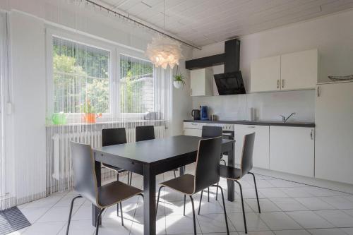 eine Küche mit einem schwarzen Esstisch und Stühlen in der Unterkunft Im Reuter in Sinsheim
