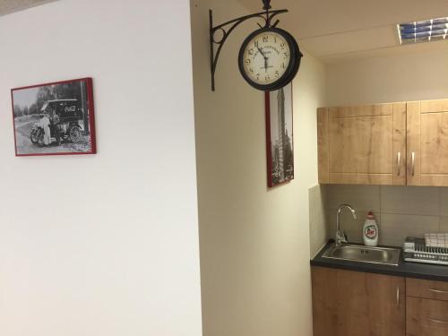 a clock hanging on a wall in a kitchen at Old Town Apartments R11 in Olomouc