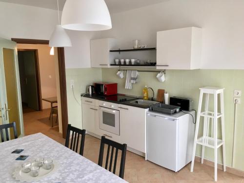 a kitchen with white cabinets and a table and a table and chairs at Apartments Novi Vinodolski in Novi Vinodolski