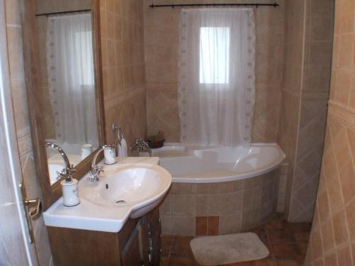 ein Badezimmer mit einem Waschbecken und einer Badewanne in der Unterkunft Nika nyaraló jakuzzival in Balatonkeresztúr