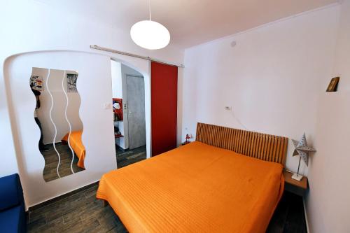 1 cama naranja en una habitación con espejo en Trsatika en Rijeka