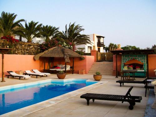 a swimming pool with a patio and a house at Casa El Morro in Uga