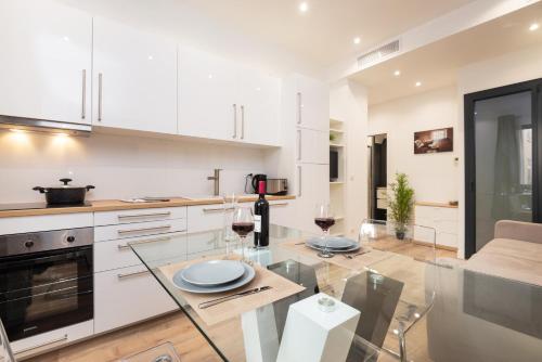 une cuisine avec des armoires blanches et une table en verre dans l'établissement 