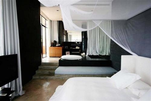 a bedroom with a bed and a living room at Sala Khaoyai in Wangkata