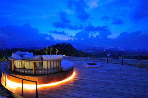 a hot tub sitting on a deck at night at Sala Khaoyai in Wangkata