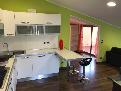 a kitchen with white cabinets and a table in a room at Mansarda a pochi passi dal mare in Brolo