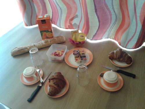 ein Tisch mit Tellern voller Essen auf einem Tisch in der Unterkunft A La Rencontre Du Soleil - Camping in Le Bourg-dʼOisans