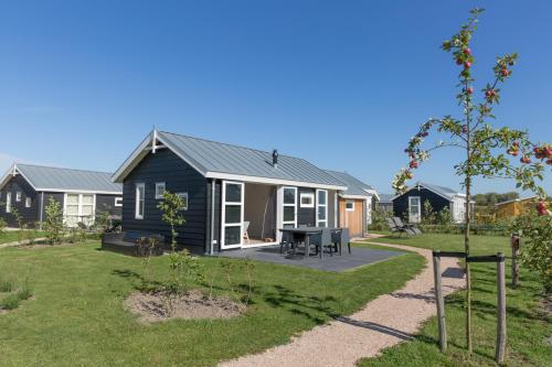 ein Haus mit einem Garten und einem schwarzen Haus in der Unterkunft Duinpark Westerschouwen in Burgh Haamstede