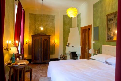 a bedroom with a bed and a table and a fireplace at Zabola Estate - Transylvania in Zăbala