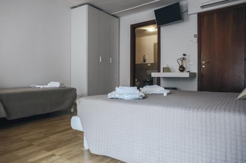 Un dormitorio con una cama blanca y un espejo. en Residenza al Castello, en Verona