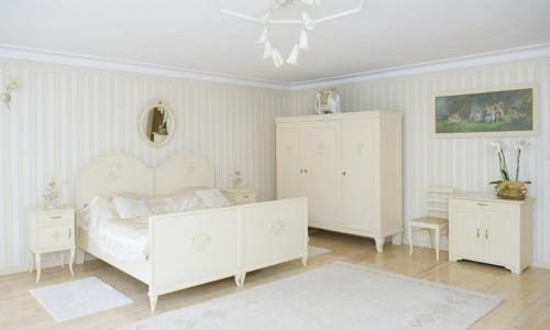 a bedroom with a white bed and two white cabinets at Pałac Brzeźno Spa & Golf in Oborniki Śląskie