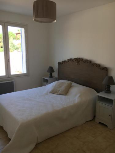 une chambre avec un grand lit blanc avec une fenêtre dans l'établissement Villa rapatel, à Saint Cyprien Plage
