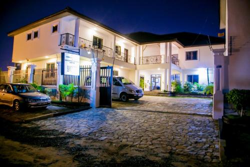 a house with two cars parked in front of it at Eden Vale Hotel in Ajiringano