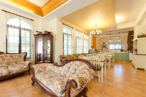 ein Wohnzimmer mit Sofas und einem Tisch und Stühlen in der Unterkunft Hasayaki Homestay in Dayi