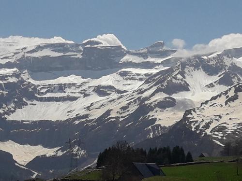 a snow covered mountain in the distance with a house at Chambres d'hôtes L'Astazou in Gavarnie