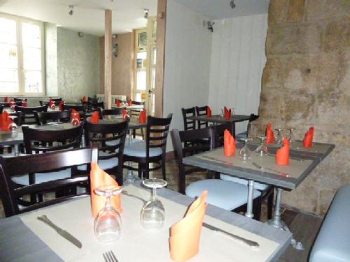 a dining room with tables and chairs with orange napkins at A La Porte Saint Jean in La Souterraine