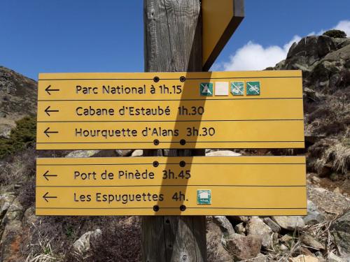 a sign on a pole with arrows on a mountain at Chambres d'hôtes L'Astazou in Gavarnie