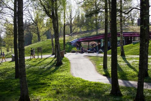 a path in a park with trees and a building at Öijared Resort in Floda