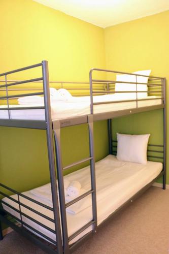 two bunk beds in a room with a green wall at Green Wall Apartment Kaprun in Kaprun