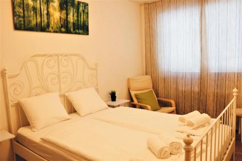 een slaapkamer met een bed, een stoel en een raam bij Green Wall Apartment Kaprun in Kaprun