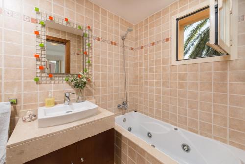 a bathroom with a tub and a sink and a bath tub at Pereta in Port d'Alcudia
