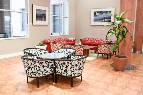 a room with couches and a table and chairs at Howard Johnson Rio Ceballos Hotel y Casino in Río Ceballos