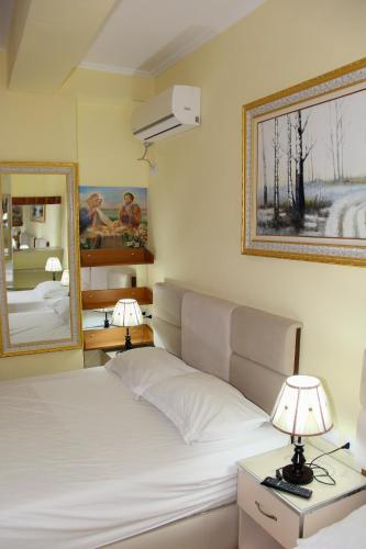a bedroom with a bed with two lamps and a mirror at Republika Hotel in Sarandë