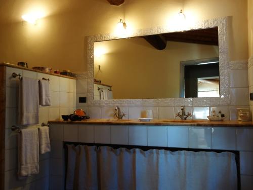 a bathroom with a sink and a large mirror at Bella di Ceciliano in Arezzo