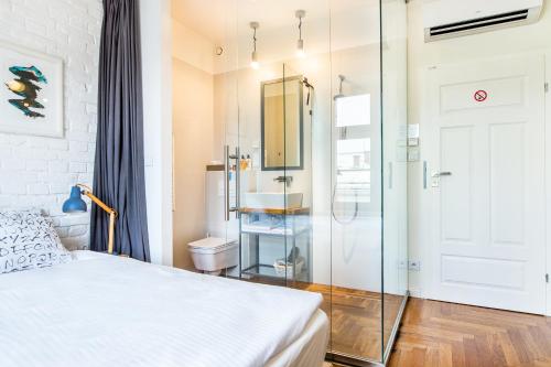 1 dormitorio con 1 cama y ducha acristalada en NOVUMHOUSE - Tomasza, en Cracovia