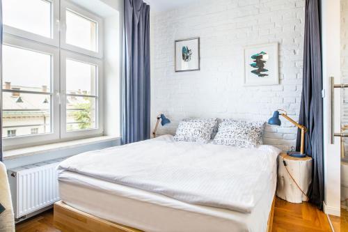 a white bedroom with a bed and a window at NOVUMHOUSE - Tomasza in Krakow