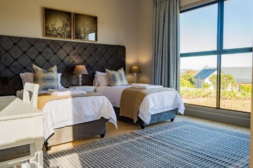 Un dormitorio con dos camas y una gran ventana. en House 222 Gowrie Farm Estate, en Nottingham Road
