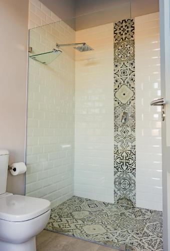 a bathroom with a white toilet and a shower at House 222 Gowrie Farm Estate in Nottingham Road
