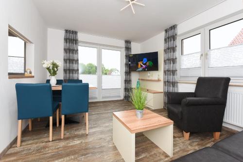 a living room with a dining room table and chairs at Haus zur Möwe mit Frühstücksoption in Bensersiel