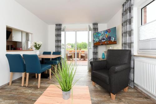 a living room with a table and a chair at Haus zur Möwe mit Frühstücksoption in Bensersiel