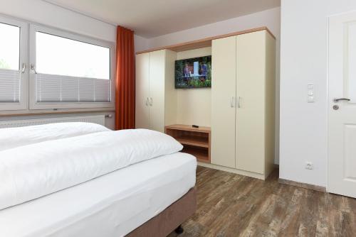 a bedroom with two white beds and a window at Haus zur Möwe mit Frühstücksoption in Bensersiel
