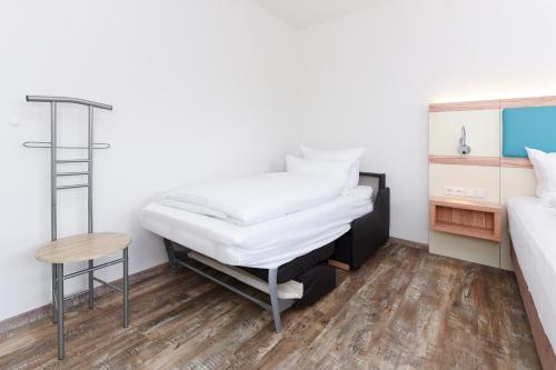 a room with a bed and a desk and a mattress at Haus zur Möwe mit Frühstücksoption in Bensersiel