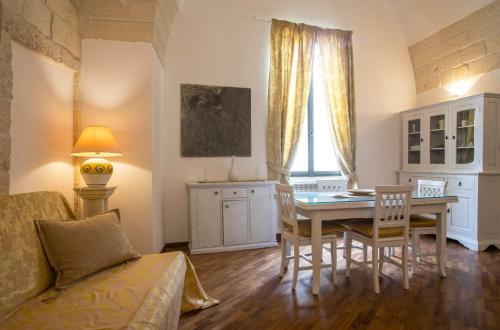 sala de estar con mesa, sillas y sofá en Chiesa Greca - SIT Rooms & Apartments, en Lecce