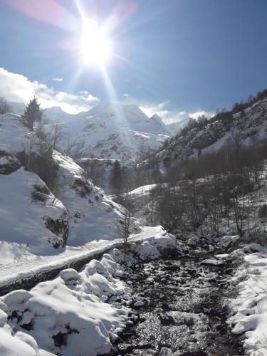 a snow covered mountain with the sun in the sky at Chambres d'hôtes L'Astazou in Gavarnie