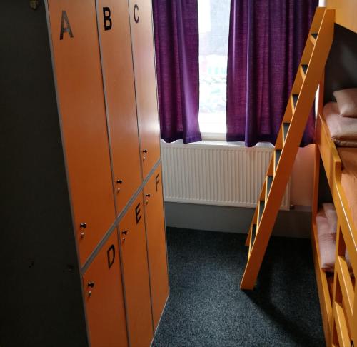 a room with bunk beds and a window with purple curtains at Birmingham Central Backpackers in Birmingham