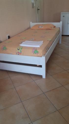 a white bed with a comforter on top of it at Chris Apartment in Preveza