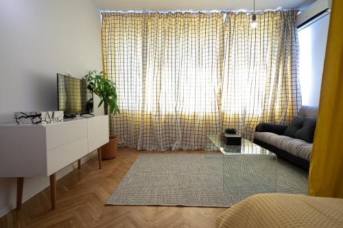 - un salon avec un canapé et une télévision dans l'établissement City Tower View, à Bucarest