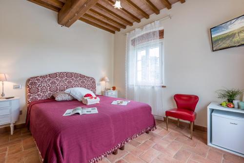 a bedroom with a red bed and a red chair at B&B Pietra a Padule in Filettole
