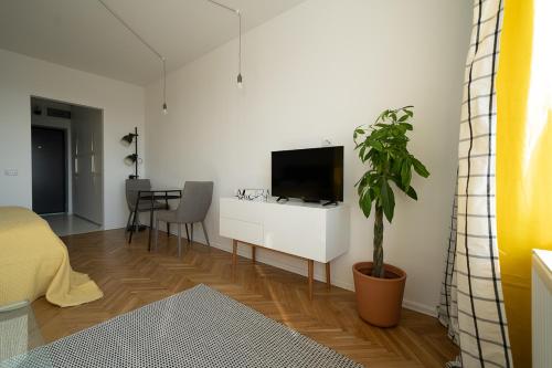 - un salon avec une télévision sur un mur blanc dans l'établissement City Tower View, à Bucarest