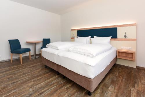 a bedroom with a large bed and a table and chairs at Haus zur Möwe mit Frühstücksoption in Bensersiel