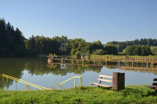 a bench sitting next to a lake with a dock at Prázdninový dům Dolce II in Trutnov