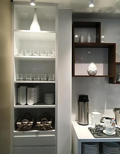 a kitchen with a pantry with plates and dishes at Hotel Alpha in Uberlândia