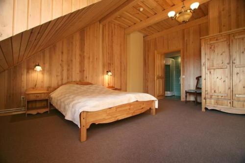 sypialnia z dużym łóżkiem i drewnianymi ścianami w obiekcie Lobes Krogs w mieście Gobas