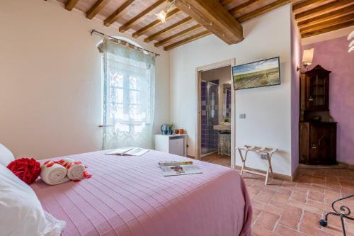 a bedroom with a large bed with a pink blanket at B&B Pietra a Padule in Filettole