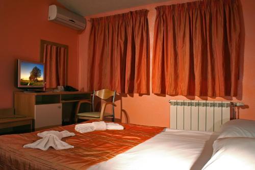 a bedroom with a bed with two towels on it at Hotel Brod - Free Parking in Sofia